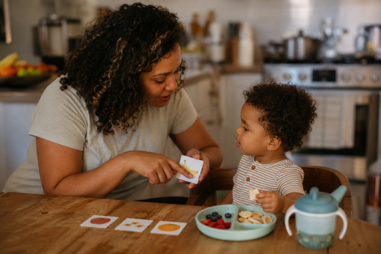 Parent modeling AAC for autistic toddler during snack time